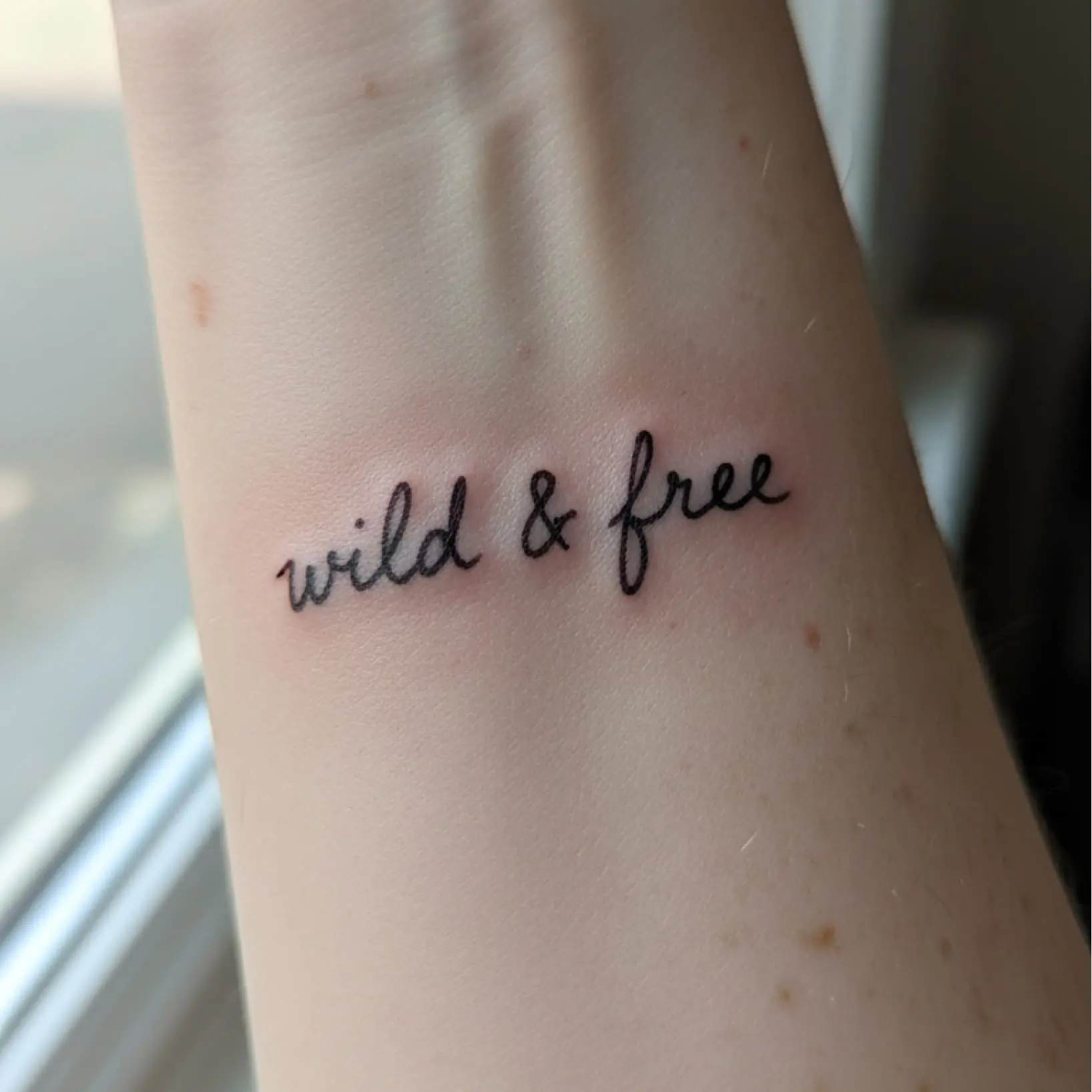 Free AI tattoo text generator interface showing custom script design previewed on wrist